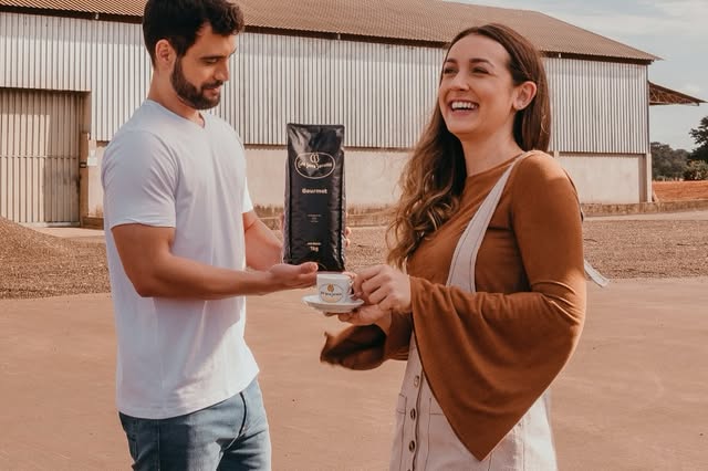 Casal servindo café no terreiro, com o pacote Gourmet em grãos